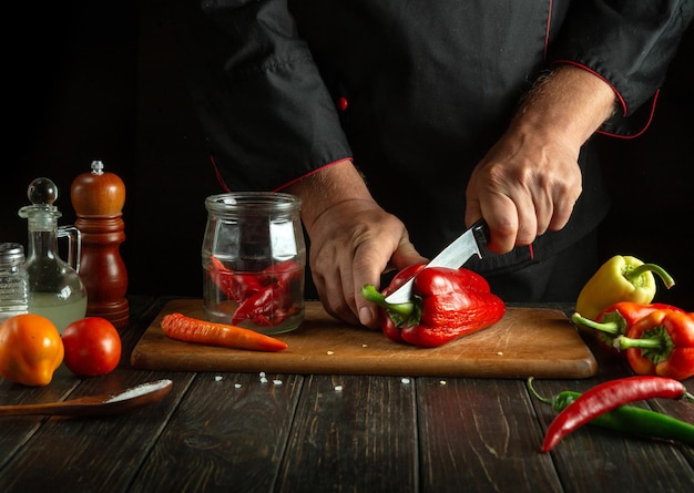 Preparación de capsicum annuum en un frasco de especias El cocinero corta pimienta roja en la cocina Concepto de preparación o enlatado de verduras