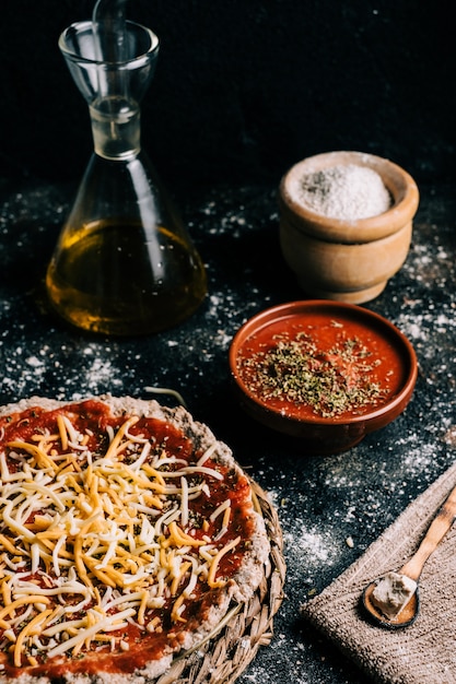 Preparación casera de pizza de cuatro quesos en la mesa de madera vieja