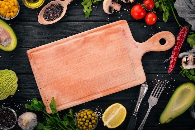 Preparación para cocinar Aguacates, tomates cherry, guisantes verdes y avellanas Sobre un fondo de madera Vista superior Espacio libre para el texto