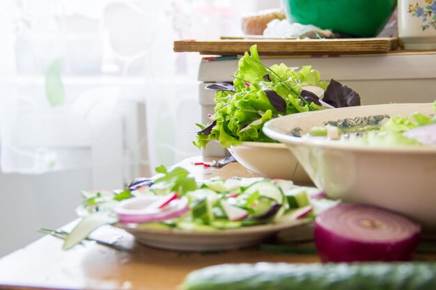 Foto preparación de ensalada con lechuga de rábano, cebolla y hojas de albahaca dieta o concepto de comida vegetariana