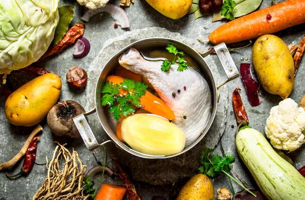 Preparación de fragante sopa de pollo con vegetales frescos.