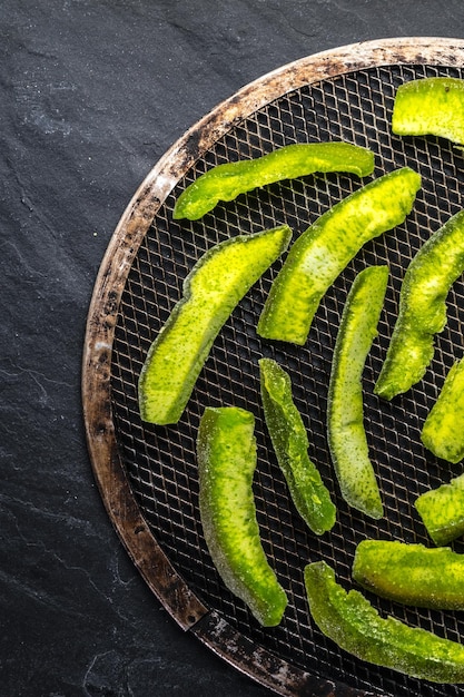 Preparación de frutas confitadas de un pamelo verde brillante en un enrejado redondo