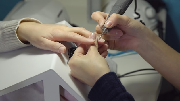 Preparación de una manicura en un salón de belleza. Mecanizado y rectificado.