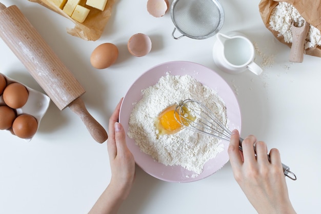 Preparación de masa para hornear vista superior en mesa blanca con ingredientes y herramientas