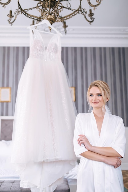 Preparación matutina de la novia con una hermosa túnica cerca