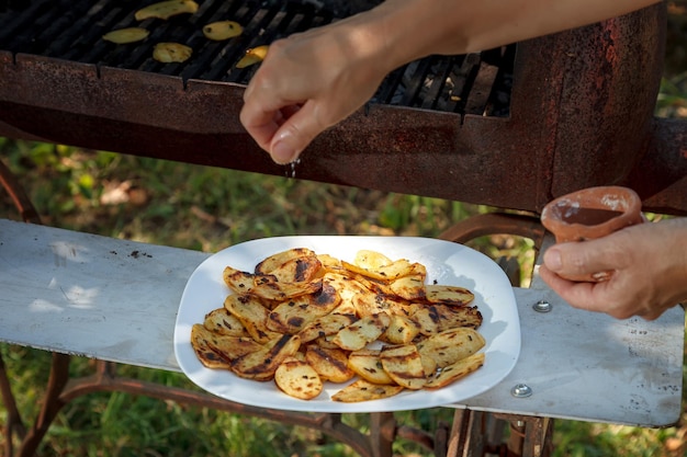 Foto preparación de papas a la parrilla echar sal a las papas