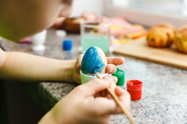 Preparación de Pascua para niños pintando huevos de Pascua y decoraciones navideñas en casa closeup