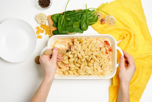 Preparación paso a paso e ingredientes para queso feta al horno con tomate y pasta, vista superior de ajo y pimienta, receta de tendencia, mezcla de macarrones con queso.