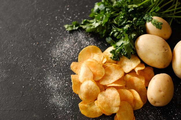 Foto preparación de patatas fritas. cocción de patatas fritas crujientes. rodajas fritas con rebanadas saladas y patatas frescas orgánicas con hierbas verdes