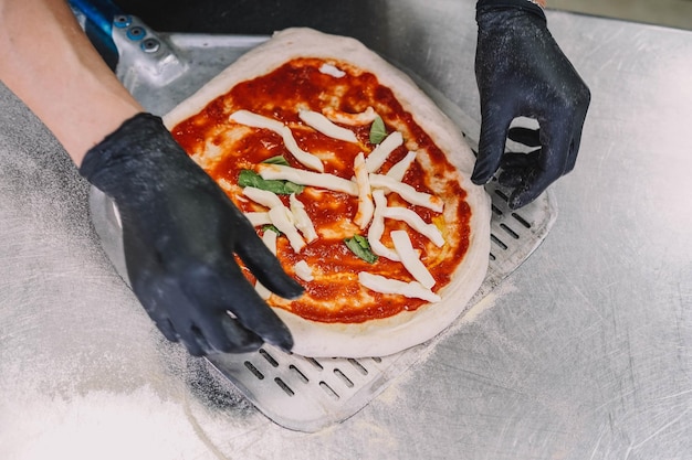Preparación de una pizza casera al estilo italiano por un especialista