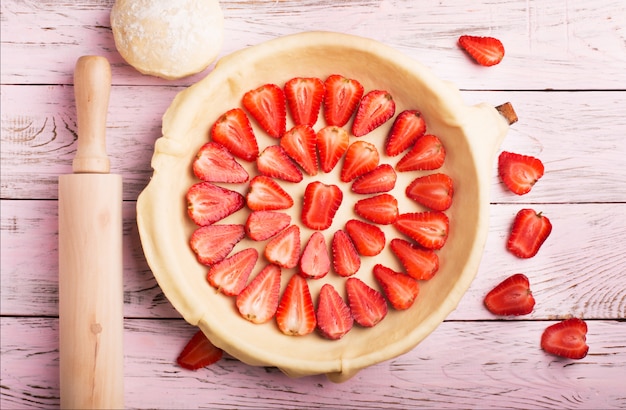 Preparación de tarta de fresas en mesa de madera