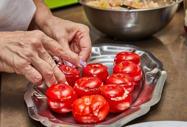 Preparación de tomates rellenos con hojas de menta en la cocina del hogar