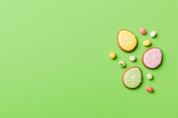 Preparación de vacaciones Huevos de Pascua de varios colores con galletas sobre fondo de color Concepto de vacaciones de huevos de Pascua de color pastel con espacio de copia