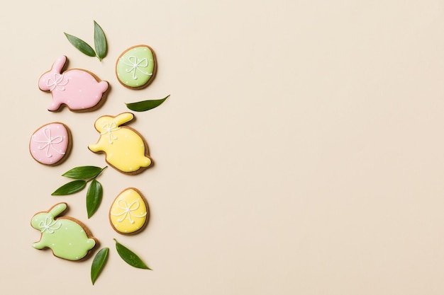 Preparación de vacaciones Huevos de Pascua de varios colores con galletas sobre fondo de color Concepto de vacaciones de huevos de Pascua de color pastel con espacio de copia