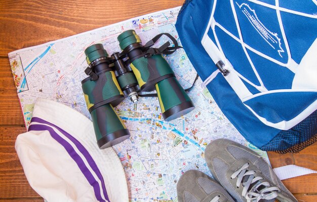 La preparación para el viaje mochila de viaje binoculares cámara mapa sobre fondo de madera