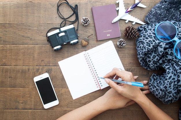 Preparación para viajes, teléfono móvil, pasaporte y cuaderno en blanco