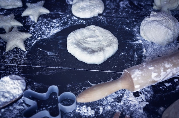 Preparaciones de masa para tartas caseras y galletas en una mesa de madera oscura. Pasteles de la casa