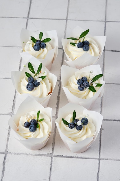 Preparações de casamento cupcakes de casamento branco decorados com ervas e flores de mirtilos frescos