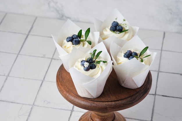 Preparações de casamento Cupcakes de casamento branco decorados com ervas e flores de mirtilos frescos