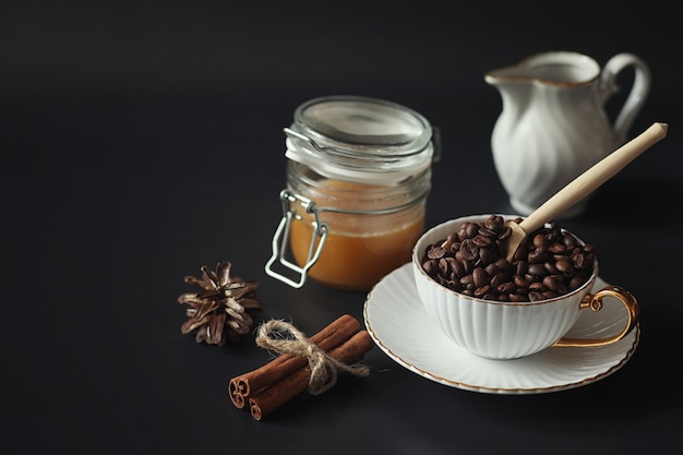 Preparado para el desayuno. Dulces y pasteles con nueces para té sobre fondo negro. Una taza de café y empanadas.