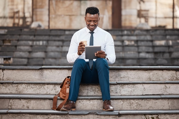 Preparados para un cambio tecnológico. Foto de un joven hombre de negocios tomando un descanso en algunos pasos mientras usa su tableta digital.