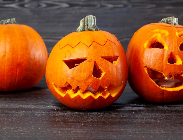 Preparando abóboras laranja para a celebração do dia das bruxas esculpidas em luzes de abóbora de pequeno jack