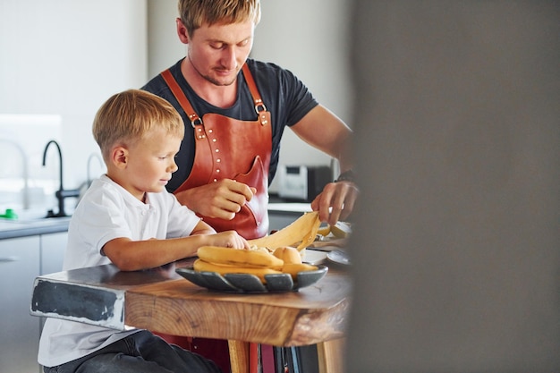 Foto preparando algo de comida padre e hijo están juntos en casa