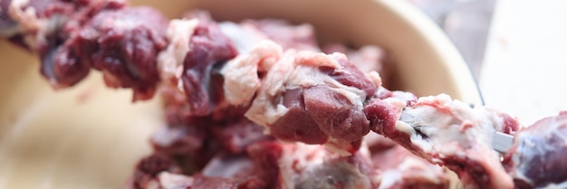 Preparando carne crua para churrasco, pedaços de carne no espeto de metal, cozinhando o conceito de comida