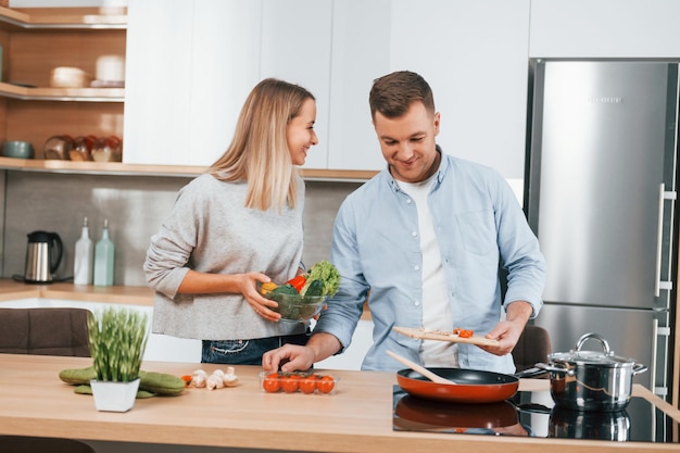 Foto preparando la cena pareja en casa en la cocina moderna