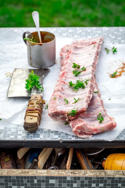 Preparando costelas inteiras com marinada e ervas para grelhar