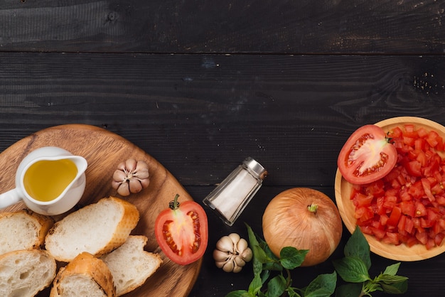 Preparando deliciosa bruscheta de tomate italiana com vegetais picados, ervas e óleo