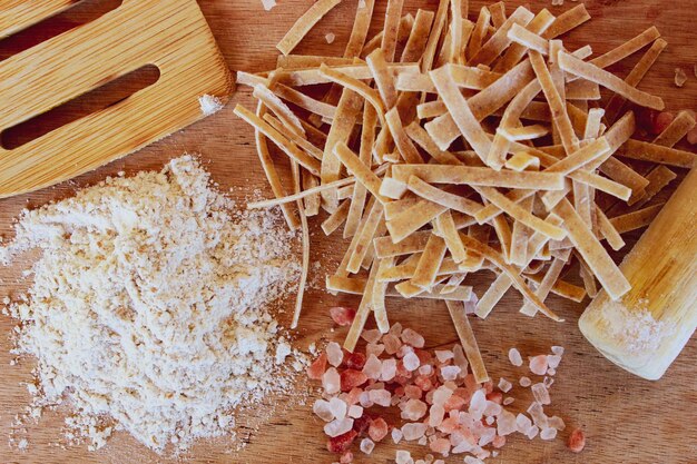 Preparando pasta casera en una mesa de madera. Proceso de elaboración de pasta casera