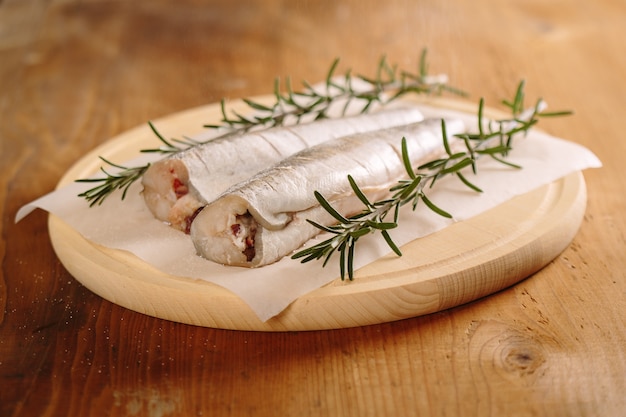 Preparando peixes de pescada fresca com estadas de sal e alecrim.