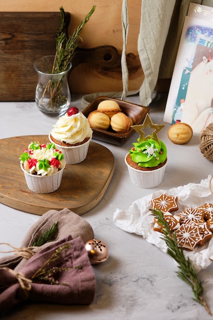 Preparando un regalo de año nuevo para amigos. Dulces para Navidad. Galletas y cupcakes de jengibre de Año Nuevo con relleno de crema de queso crema y caramelo.