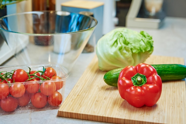 Preparando salada de vegetais verdes frescos com pepino de tomate cereja