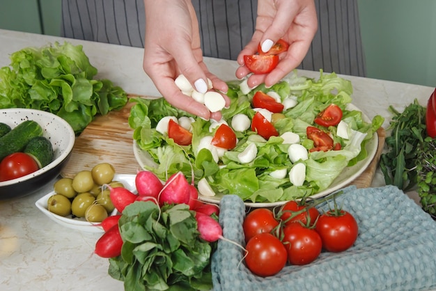 Preparando uma salada de legumes com tomate e mussarela