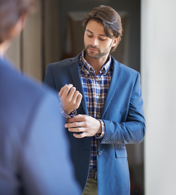 Preparándose para el día Foto de un hombre guapo preparándose para el trabajo