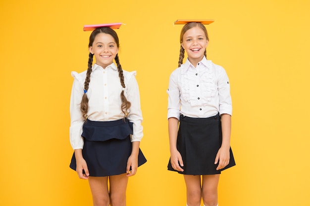 Foto preparándose para los exámenes de regreso a la escuela compañeros de clase en librería o biblioteca lección de literatura literatura infantil lectura y escritura niñas felices estudian con libro de trabajo niñas pequeñas niños con libro