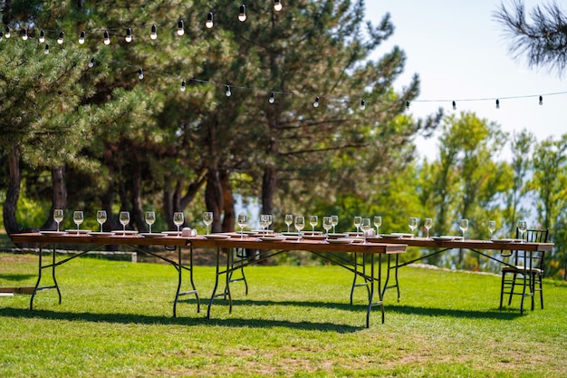 Preparándose para una fiesta al aire libre. Mesas decoradas servidas esperan a los invitados. Detalles de decoracion