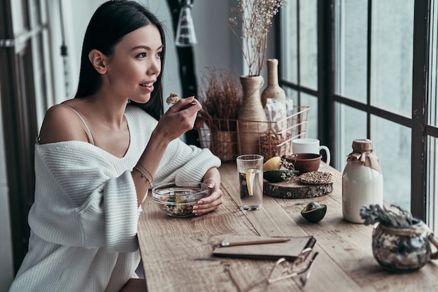 preparándose para un largo día. Atractiva mujer joven comiendo un desayuno saludable