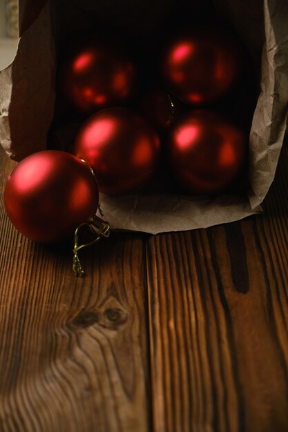 Preparándose para la Navidad. Decoraciones para el árbol de Navidad. Bolas de Navidad rojas en una caja sobre una mesa de madera
