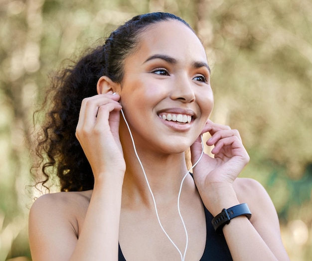 Foto preparándose para su carrera matutina. una foto de una joven deportista escuchando música mientras hace ejercicio al aire libre.