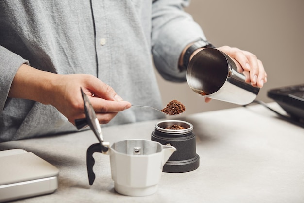 Preparar a máquina de café Geyser enchendo a xícara com café médio recém-moído