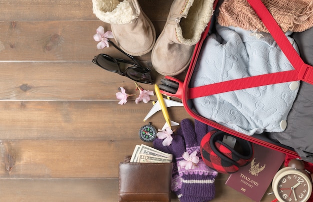 preparar accesorios y artículos de viaje para el viaje de invierno en la tabla de madera vieja, endecha plana, vista desde arriba centrico