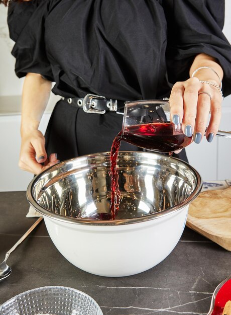 Preparar un delicioso vino caliente con vino tinto y especias aromáticas en una cocina acogedora