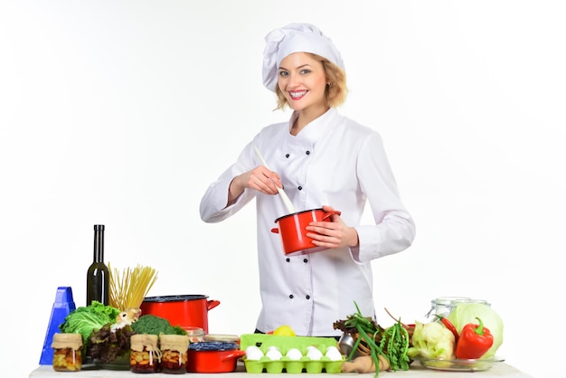 Preparar platos joven cocinera preparar comida en la mesa cocinero profesional en traje blanco mujer