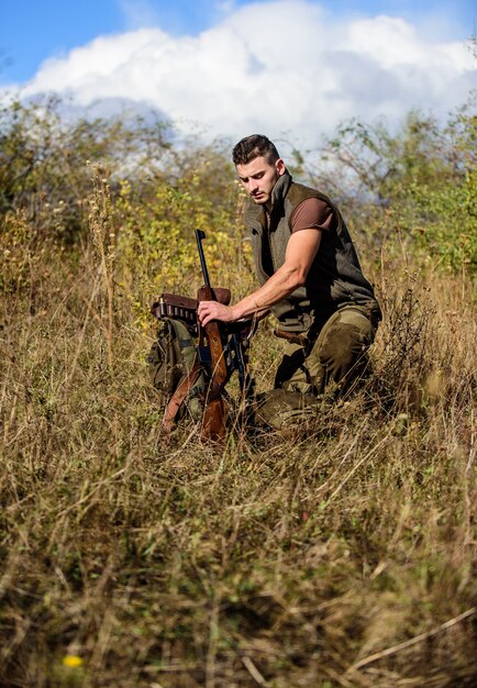 Prepárate para cazar. Lo que debe tener mientras caza el entorno natural. Hombre con fondo de naturaleza de equipo de caza de rifle. Recargar el concepto de rifle. Equipo de caza y medidas de seguridad.