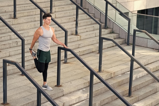 Prepárate para el jog guy calentándose antes del entrenamiento de fondo urbano