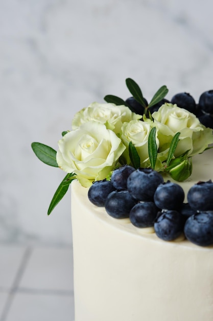 Preparativos do casamento Bolo de casamento branco decorado com mirtilos frescos e flores