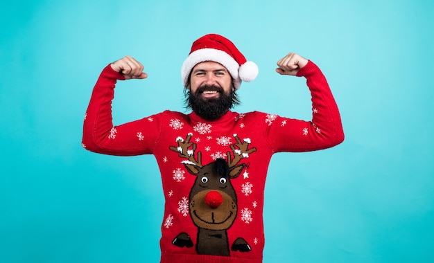 Preparativos para as férias de inverno. venda de presentes e compras de presentes. feliz Ano Novo. Feliz Natal. alegre homem barbudo com chapéu de Papai Noel e camisola. hipster brutal comemorar a festa de natal.